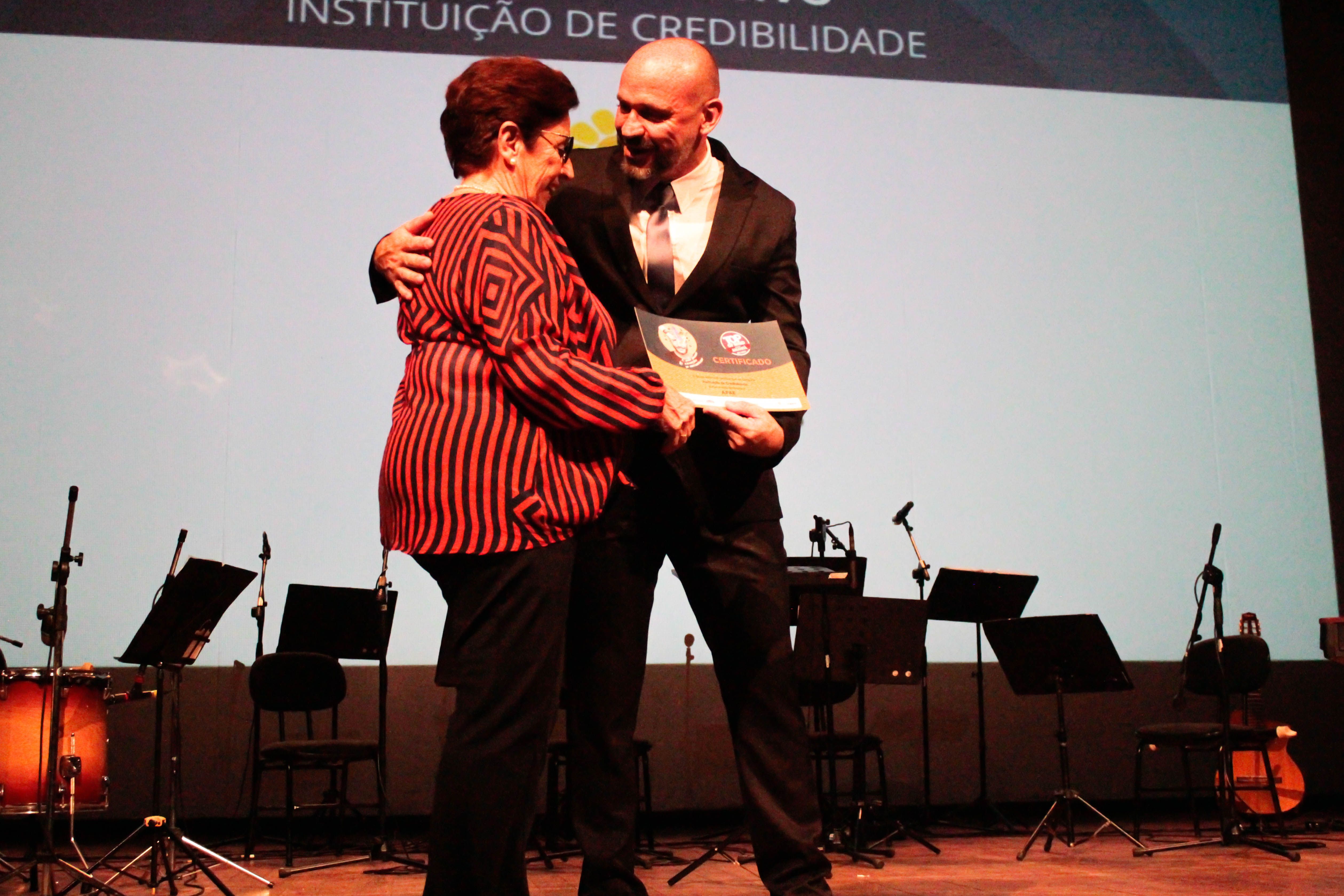 Aracy Ledo, presidente da FEAPAES-RS recebendo o certificado Top of Mind 2023.